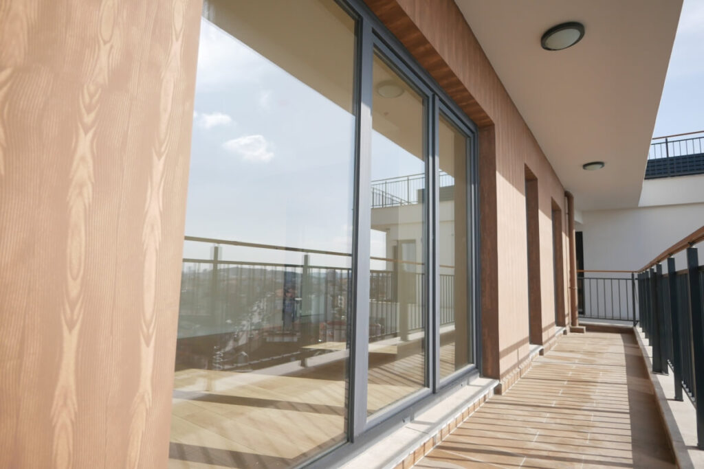 Na zdjęciu widoczne są duże okna aluminiowe w nowoczesnym budynku.